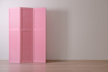 Pink folding screen in room