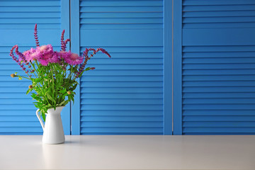Beautiful wildflowers bouquet on blue folding screen background