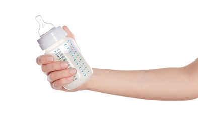 Female hand holding a baby bottle of milk on white background