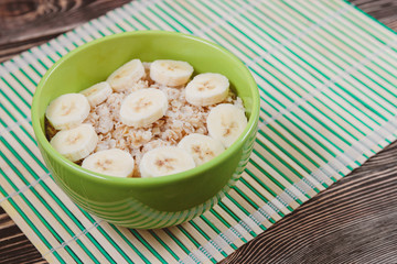 Tasty Oatmeal Porridge with Bananas in Green bowl
