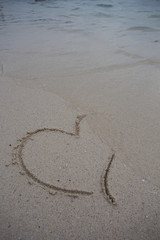 hearts drawn on the sand of a beach
