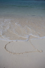 hearts drawn on the sand of a beach