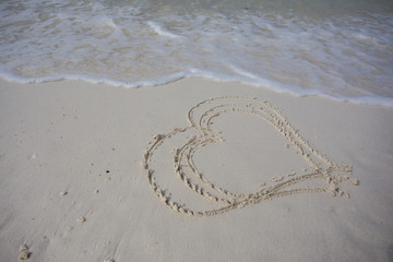 hearts drawn on the sand of a beach