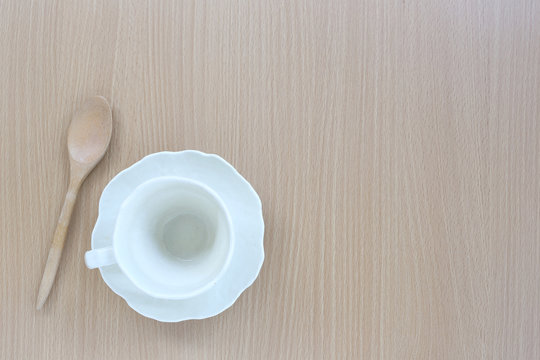 White coffice cup and wooden spoon in top view on wood backgroun