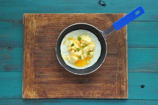 Flat lay of scrambled eggs served in a rustic pen