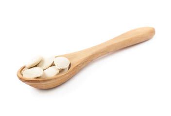 Wooden spoon full of pumpkin seeds