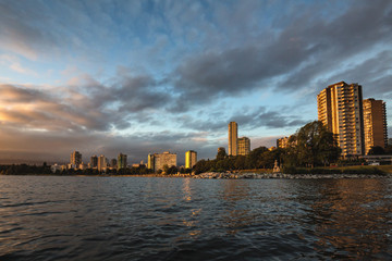 View of English Bay Beach in Downtown Vancouver, BC, Canada, during a beautiful cloudy sunset.