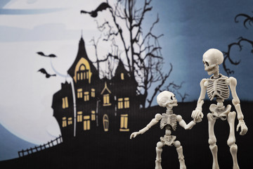 Skeleton and little skeleton with Halloween background