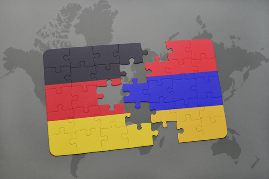 puzzle with the national flag of germany and armenia on a world map background.