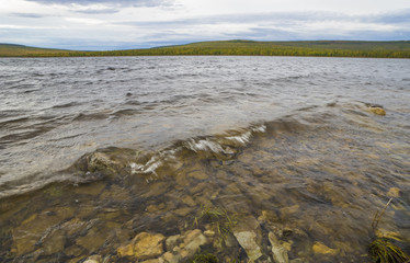 Summer landscape with river, cloudy sky and sun.