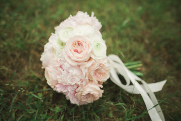 Bouquet of beautiful flowers and greenery is on the green grass