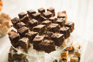 Delicious and tasty dessert table with cupcakes shots at reception closeup