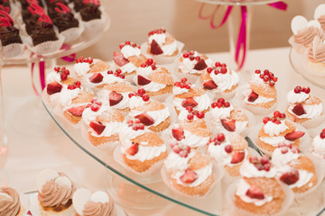 Delicious and tasty dessert table with cupcakes shots at reception closeup