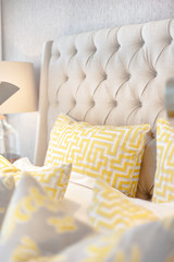 Yellow pillows with a maze art on the bed closeup
