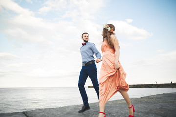 Wedding couple, bride, groom walking and posing on pier
