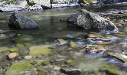 Fototapeta na wymiar The river - flowing water between the rocks.