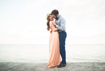 Beautiful loving couple, pride with long dress walking on pier