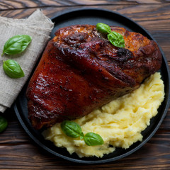 Top view of roasted pork knuckle with mashed potato, close-up