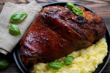 Close-up of baked pork knuckle served with potato puree