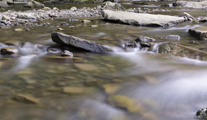The river - flowing water between the rocks.