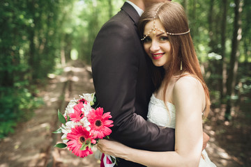 Naklejka premium passionate kiss of newlyweds somewhwere in the park on the sunset