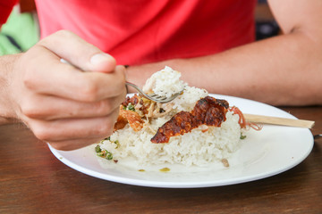 Man eating babi guling. Babi guling (suckling pig) is one of Bali’s most famed dishes. Pig is stuffed with spicy concoction ,turmeric, coriander, lemongrass, pepper, garlic