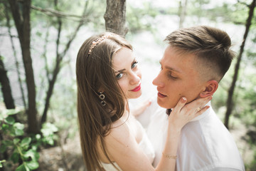 Fototapeta premium Wedding couple man, bride kissing and hugging on a background of the river, mountains. Beauty portrait