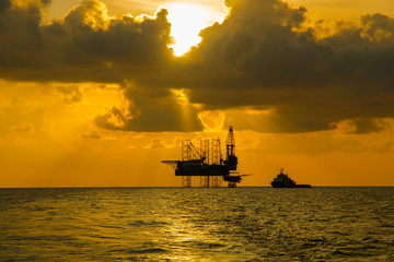 Silhouette,Offshore Jack Up Rig in The Middle of The Sea at Sunset Time