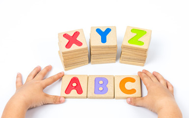 Kid hands playing wooden alphabets block