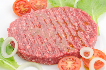 Raw burger closeup on a white plate