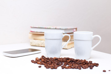 Two white cups of coffee standing on a white table