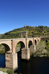 Fototapeta na wymiar Roman bridge over the Tajo river in Valencia de Alcantara, Extremadura, Spain.(In the top view of the town of Valencia de Alcantara)