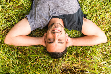 Close-up of man holding hands behind head