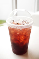 Fresh ice tea in plastic glass with straw