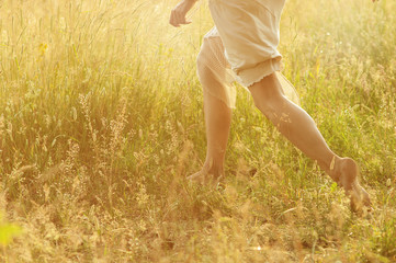   girl's feet running on a grass