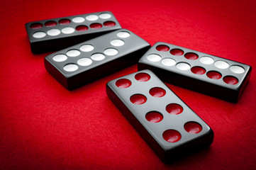 Chinese dominos on a red felt table background in the vintage casino game of Pai Gow tiles