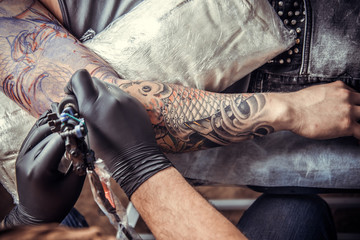 Tattoo specialist working tattooing in tattoo parlour