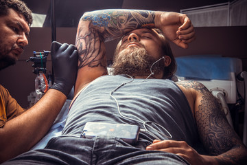 Tattoo artist making a tattoo in tattoo parlor