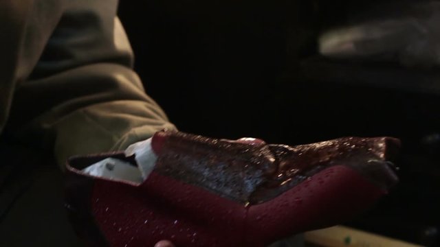 Spray liquid bottle in the shoes. Shoemaker sews shoes.