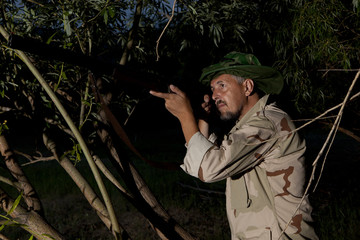 Man in mosquito net ready to hunt with hunting rifle © Andrey Burmakin
