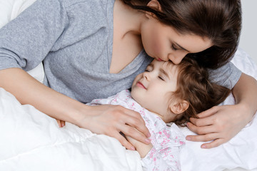 Fototapeta na wymiar Beautiful mother and daughter in bed
