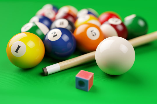 Group of billiard colored balls, cue and chalk on green table. 3