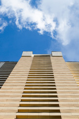 Fototapeta na wymiar High-rise building modern architecture. Looking up blue sky white clouds, daylight urban landscape background