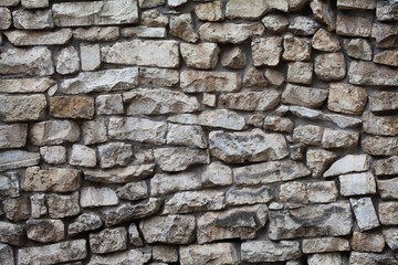 Fototapeta premium Stone wall background. Textured pattern facade building. macro soft focus