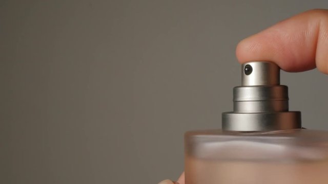 Perfume bottle spray in the dark 4K 2160p UHD footage - Parfum container spraying by the hand in the dark 4K 3840X2160 UHD video 