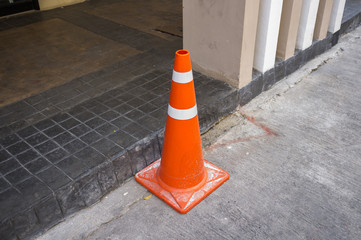 Traffic cone or construction cone / pylon with concrete background, safety caution concept