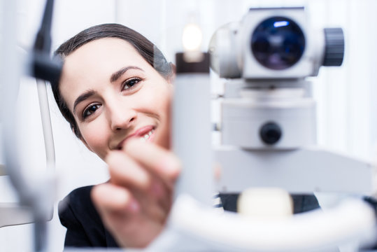 Optiker mit Refraktometer vor Untersuchung
