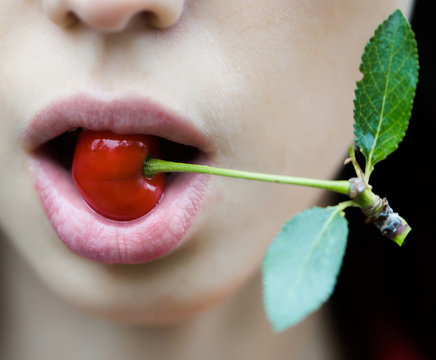 Red cherry in sensual mouth
