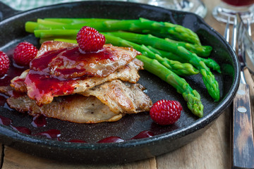 Pork cutlets with raspberry sauce and asparagus, horizontal