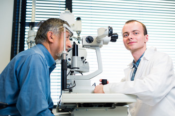 Naklejka na ściany i meble Optometry concept - senior man having his eyes examined